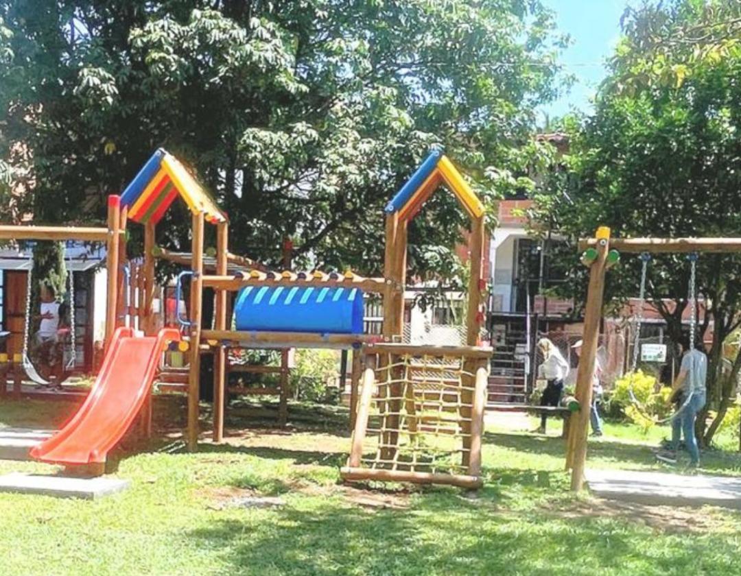 Parque infantil con integrados recreativos en madera y bases en cemento en el Portal de las Flores
